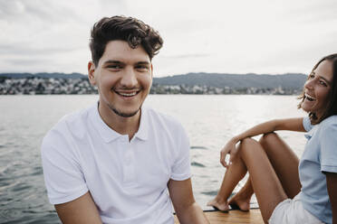 Glückliches junges Paar bei einer Bootsfahrt auf einem See - LHPF00939