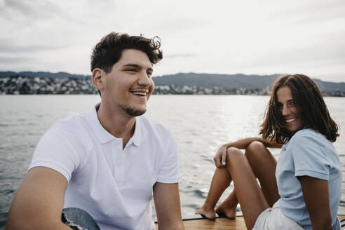 Glückliches junges Paar bei einer Bootsfahrt auf einem See - LHPF00940