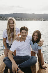 Porträt von glücklichen Freunden bei einer Bootsfahrt auf einem See - LHPF00943