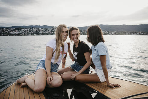 Glückliche Freundinnen, die sich bei einer Bootsfahrt auf einem See amüsieren - LHPF00949