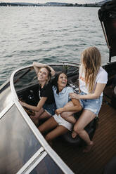 Glückliche Freundinnen, die sich bei einer Bootsfahrt auf einem See amüsieren - LHPF00950