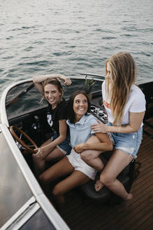 Glückliche Freundinnen, die sich bei einer Bootsfahrt auf einem See amüsieren - LHPF00951