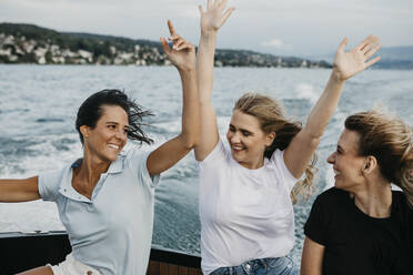 Glückliche Freundinnen, die sich bei einer Bootsfahrt auf einem See amüsieren - LHPF00953