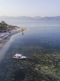 Luftaufnahme eines Bootes auf dem Meer auf der Insel Gili-Air gegen den klaren Himmel bei Sonnenuntergang, Bali, Indonesien - KNTF03482