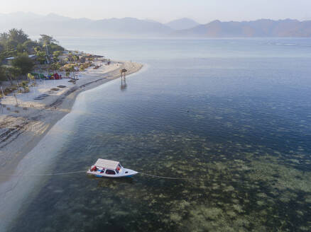 Drohnenaufnahme eines Bootes auf dem Meer bei der Insel Gili-Air gegen den klaren Himmel bei Sonnenuntergang, Bali, Indonesien - KNTF03483