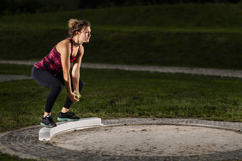 Femal shot-putter training with ball stock photo