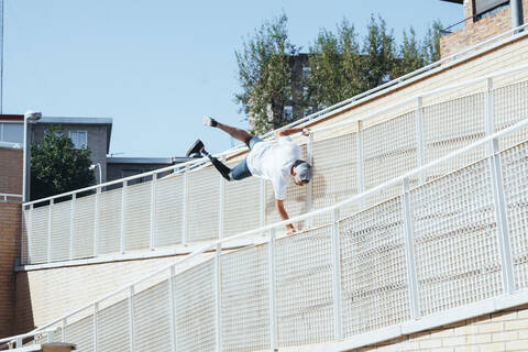 Junger Mann mit Beinprothese beim Parkour in der Stadt, lizenzfreies Stockfoto