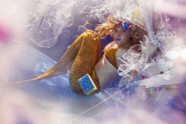 Teenage mermaid girl surrounded by plastic waste under water - STBF00398