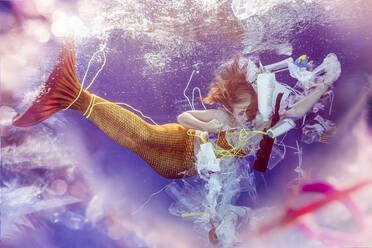Dspaired teenage mermaid girl caught in plastic waste under water - STBF00404