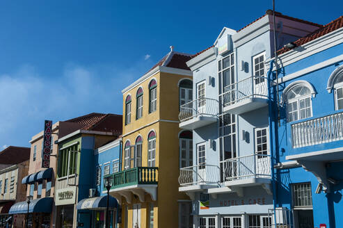 Niedriger Winkel Blick auf bunte Gebäude gegen den blauen Himmel in Willemstad während des sonnigen Tages, Curaçao - RUNF03219