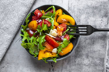 Schüssel mit Salat mit roten und gelben Tomaten, Rucola und Parmesan - SARF04351