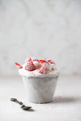 Close-up of strawberry ice cream served in bowl with spoon on table - MYF02164