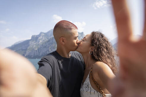 Junges Paar macht Selfie beim Küssen, Lecco, Italien - MCVF00048