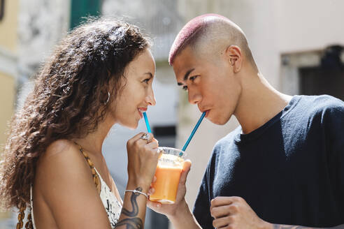 Young couple drinking fruit juice together - MCVF00059
