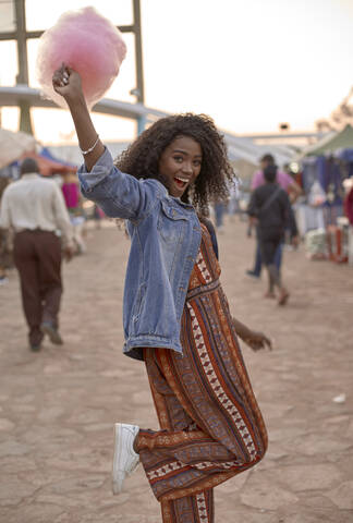 Portrait of happy young woman with pink candyfloss on street market stock photo