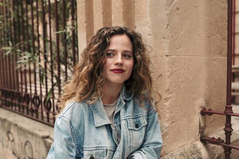 Beautiful young woman with curly hair and glasses in the city - LOTF00075