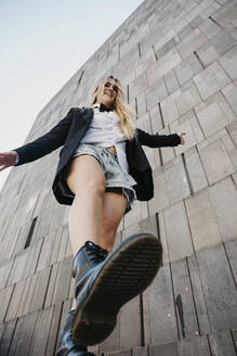 Junge Frau balanciert auf einem Bein, MuseumsQuartier, Wien, Österreich - LHPF00964