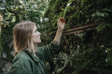 Young woman touching plants - LHPF00986