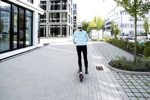 Mature woman riding electric scooter in the city - FLLF00298