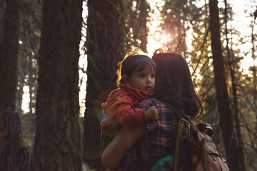 Mutter hält ein kleines Mädchen im Wald bei Sonnenuntergang im Sequoia National Park, Kalifornien, USA - GEMF03174