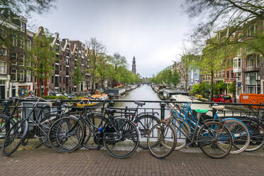 Niederlande, Amsterdam, Fahrräder am Geländer einer Grachtenbrücke abgestellt - XCF00235