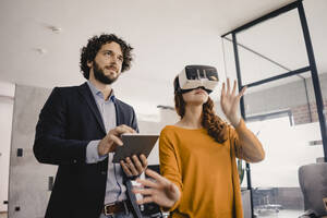 Geschäftsmann und Geschäftsfrau mit VR-Brille und Tablet im Büro - KNSF06596