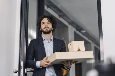 Architect in office holding architectural model - KNSF06601
