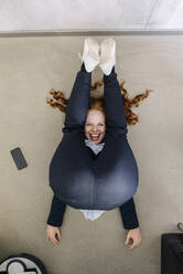 Geschäftsfrau auf dem Boden liegend im Büro beim Sport - KNSF06646