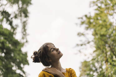 Relaxed young woman in a park - KNSF06663