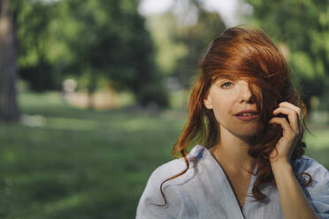 Porträt einer schönen rothaarigen Frau in einem Park - KNSF06665