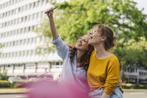 Zwei glückliche Freundinnen machen ein Selfie in der Stadt - KNSF06689