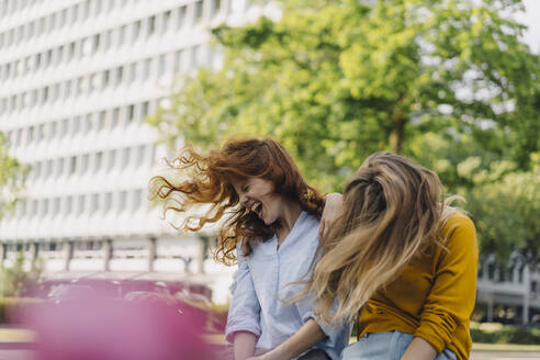 Two exuberant female friends headbanging in the city - KNSF06690