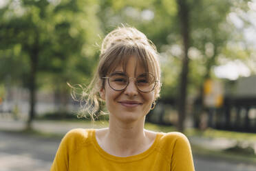 Portrait of smiling young woman with glasses - KNSF06692