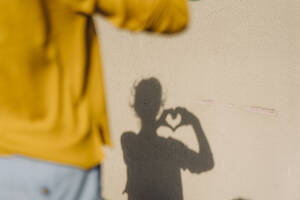 Shadow of a woman shaping a heart with her hands - KNSF06693