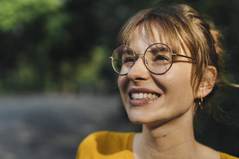 Portrait of smiling young woman with glasses - KNSF06695