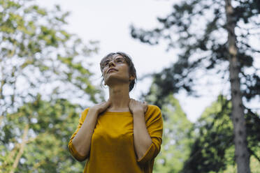 Junge Frau in einem Park mit Blick nach oben - KNSF06697