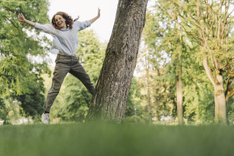 Porträt einer glücklichen rothaarigen Frau in einem Park, lizenzfreies Stockfoto