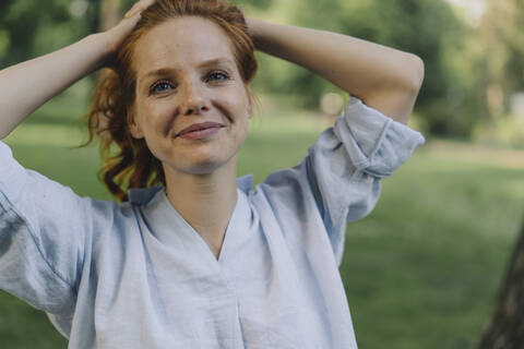 Portrait of redheaded woman in a park stock photo