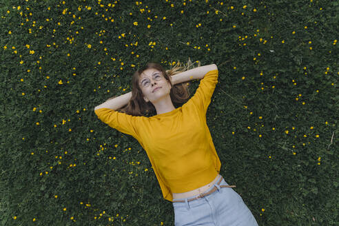 Junge Frau auf einer Blumenwiese liegend - KNSF06731