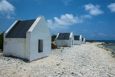 Sklavenhütten am Strand vor blauem Himmel in Bonaire, ABC-Inseln, Karibik Niederlande - RUNF03318