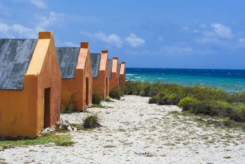 Slave huts at beach against blue sky during sunny day, Bonaire, ABC Islands, Caribbean Netherlands - RUNF03319