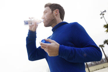 Portrait of jogger, drinking from water bottle - JSRF00649