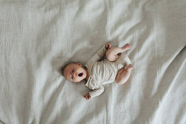 Baby auf dem Bett liegend - JOHF00997