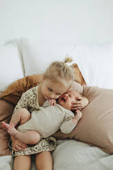 Girl with newborn sibling on bed - JOHF01020