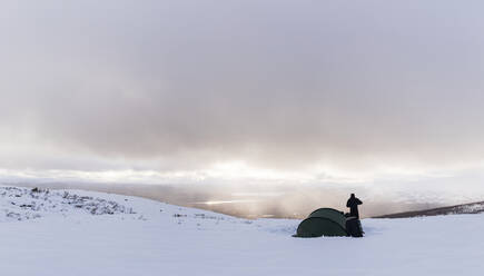 Wanderer, der im Winter sein Lager aufschlägt - JOHF01033