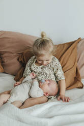 Girl with newborn sibling on bed - JOHF01042