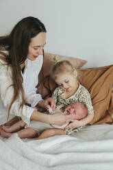 Mother with children on bed - JOHF01043