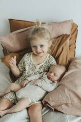Mädchen mit neugeborenem Geschwisterchen auf dem Bett - JOHF01047