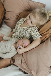 Girl with newborn sibling on bed - JOHF01049