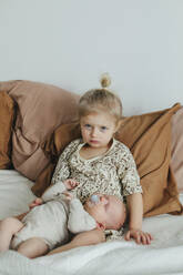 Girl with newborn sibling on bed - JOHF01050